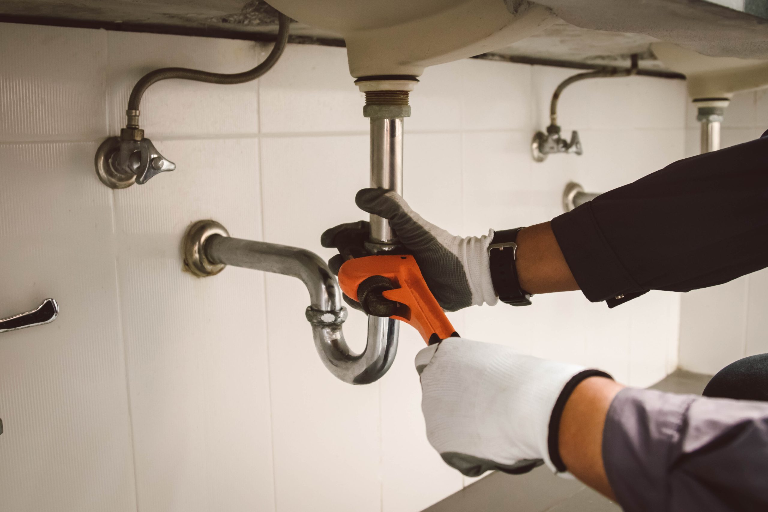 plumber at work in a bathroom, plumbing repair service , fix water plumbing leaks, replace the kitchen sink drain